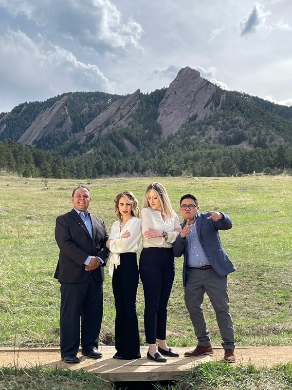 a group of people standing in front of a mountain