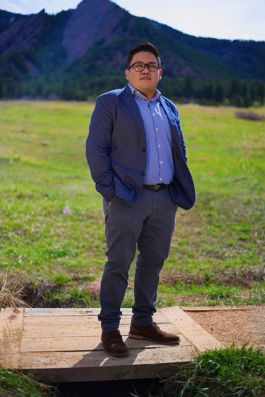 a man standing on top of a grass covered field